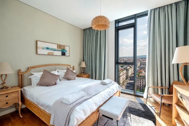 Camera da letto con grande vetrata e vista sulla città