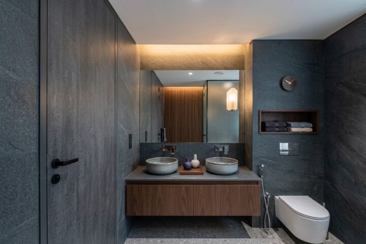 Bagno moderno in pietra scura con doppio lavabo fotografato da Keyvan Jafari